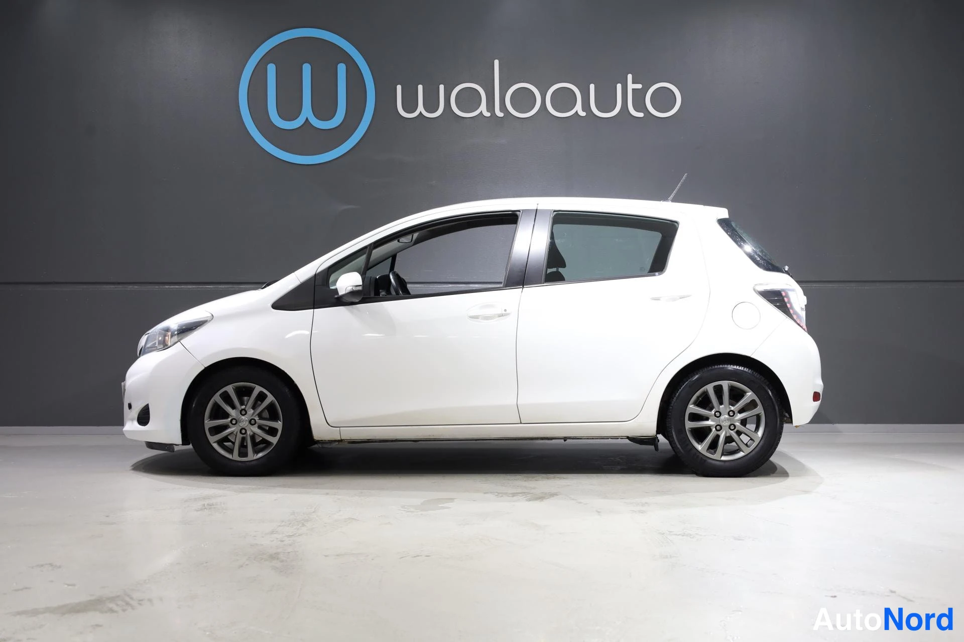 Valkoinen Toyota Yaris 2014, etuviisto, keula vasemmalle, kuva 2