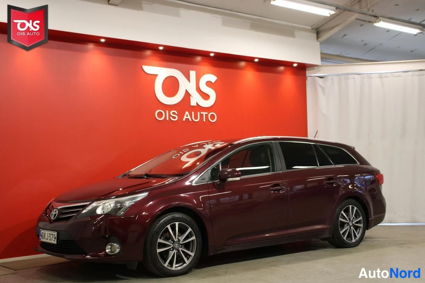 Röd Toyota Avensis 2012, snett framifrån, fronten åt vänster, bild 2