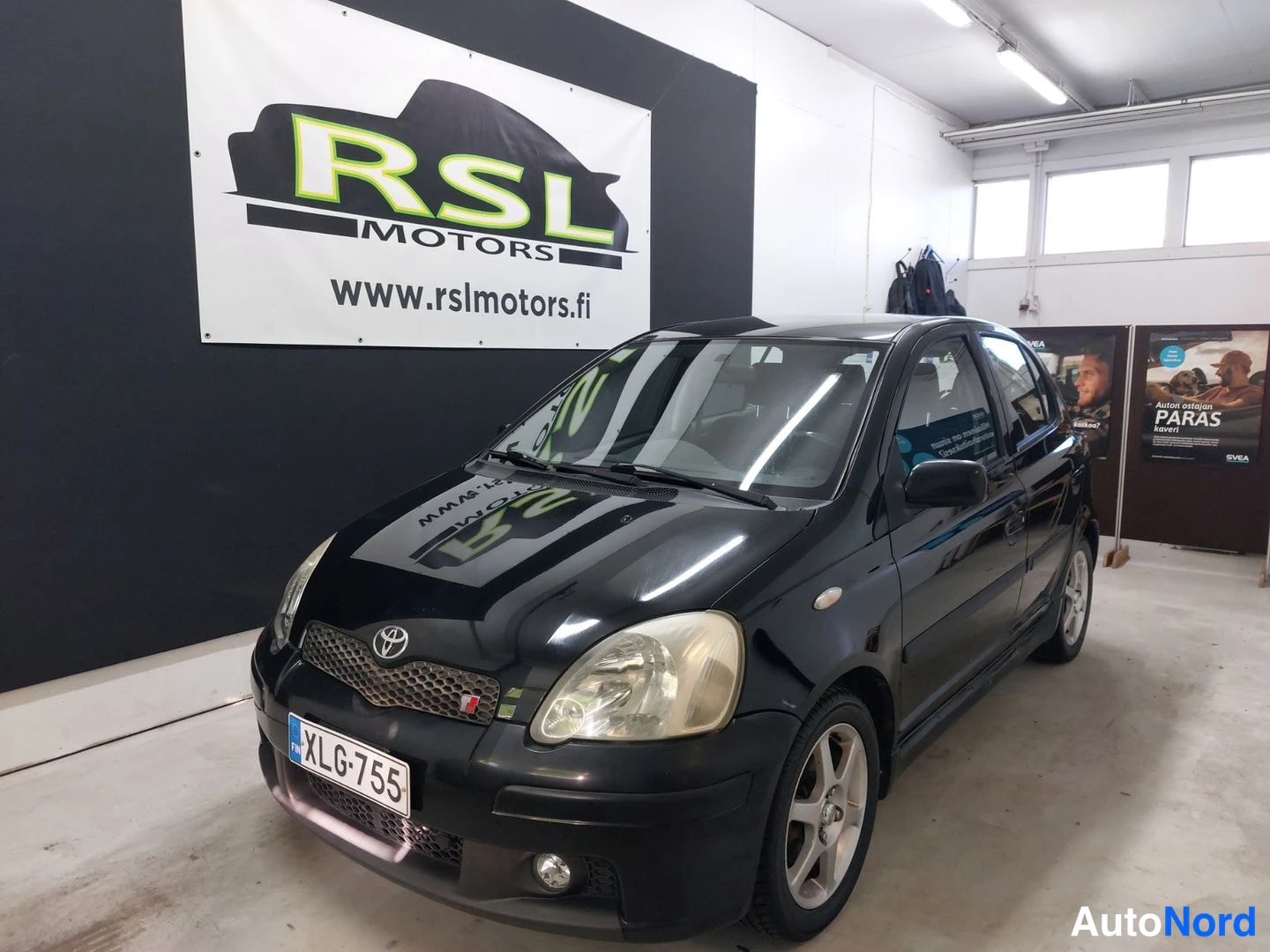 Musta Toyota Yaris 2004, etuviisto, keula vasemmalle, kuva 2