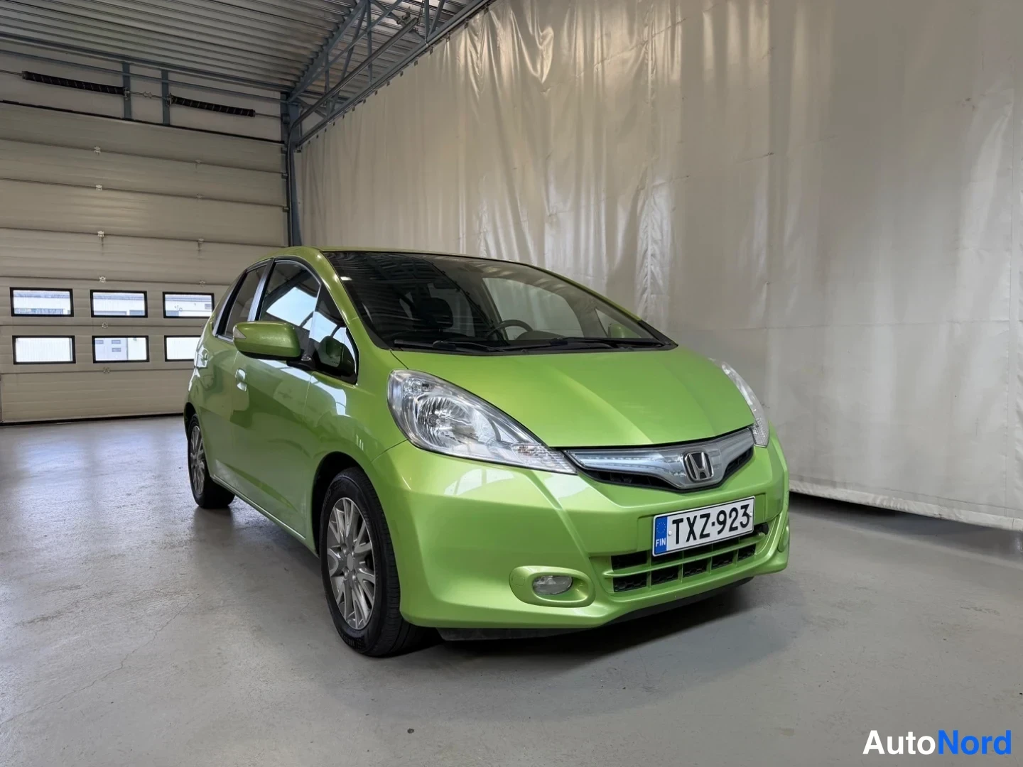 Grön Honda Jazz 2012, snett framifrån, fronten åt höger, bild 2