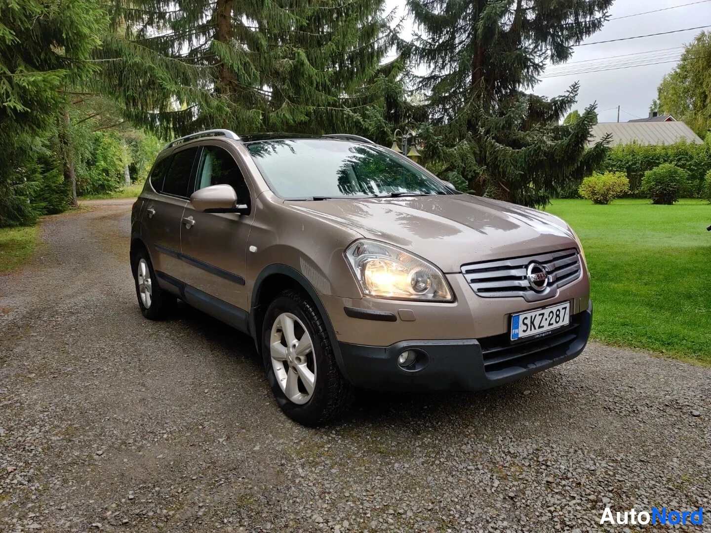Beige Nissan Qashqai+2 2009, snett framifrån, fronten åt höger, bild 8