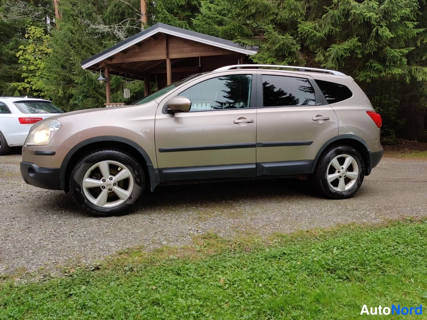 Beige Nissan Qashqai+2 2009, snett framifrån, fronten åt vänster, bild 5