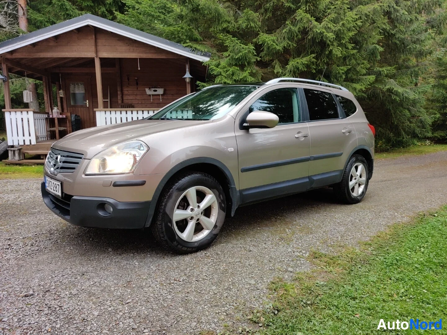 Beige Nissan Qashqai+2 2009, snett framifrån, fronten åt vänster, bild 2