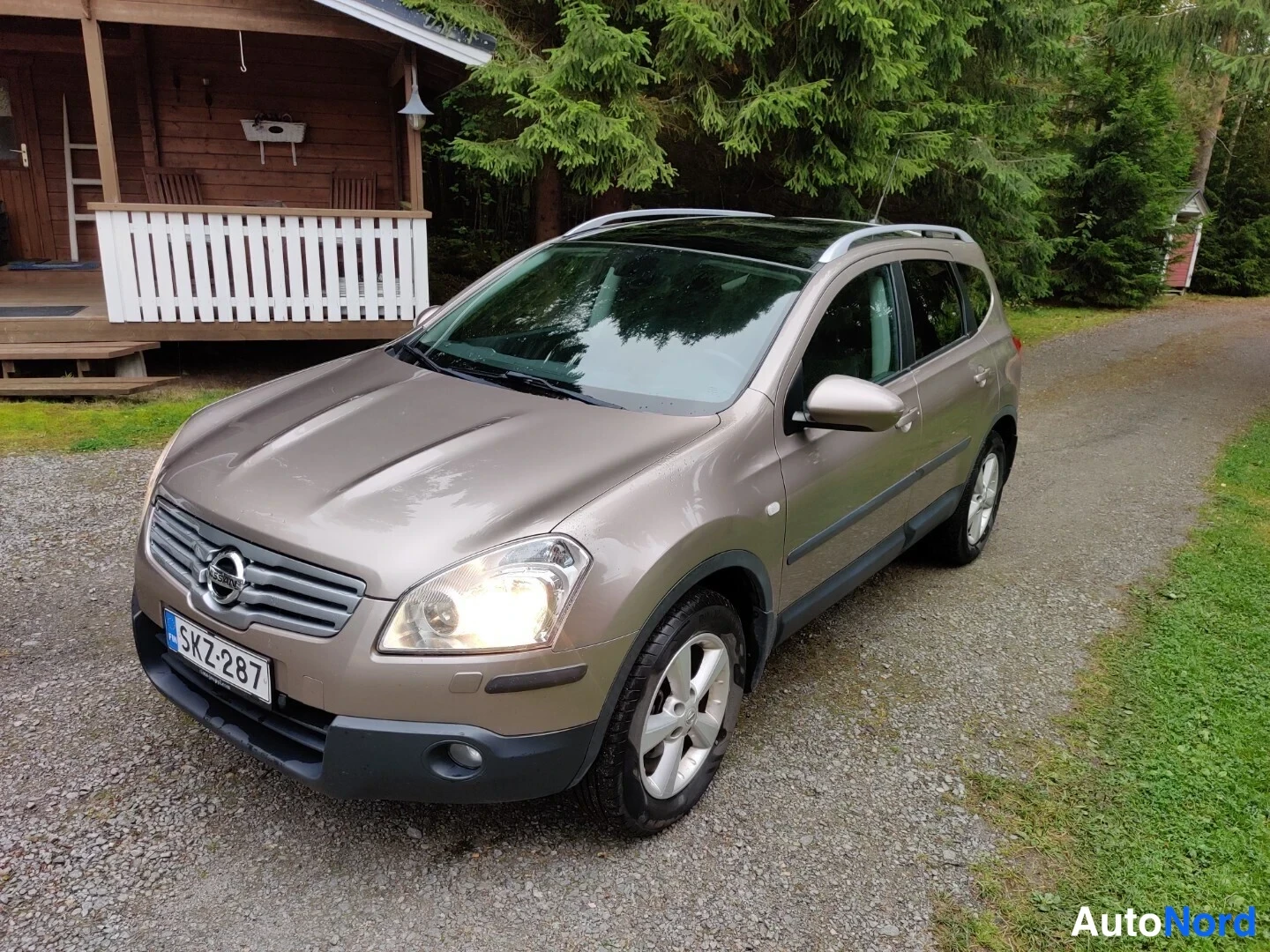 Beige Nissan Qashqai+2 2009, snett framifrån, fronten åt vänster, bild 3