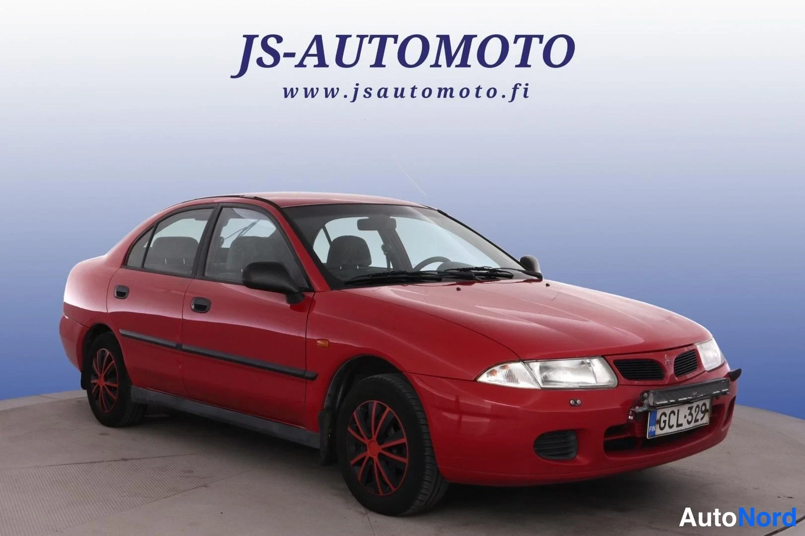 Röd Mitsubishi Carisma 1997, snett framifrån, fronten åt höger, bild 2