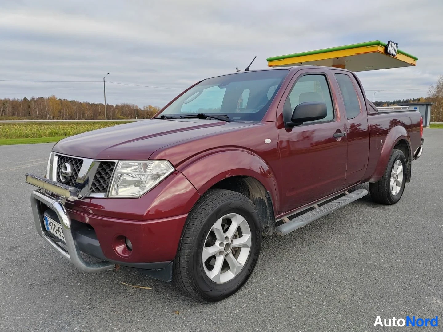 Punainen Nissan Navara 2007, etuviisto, keula vasemmalle, kuva 2