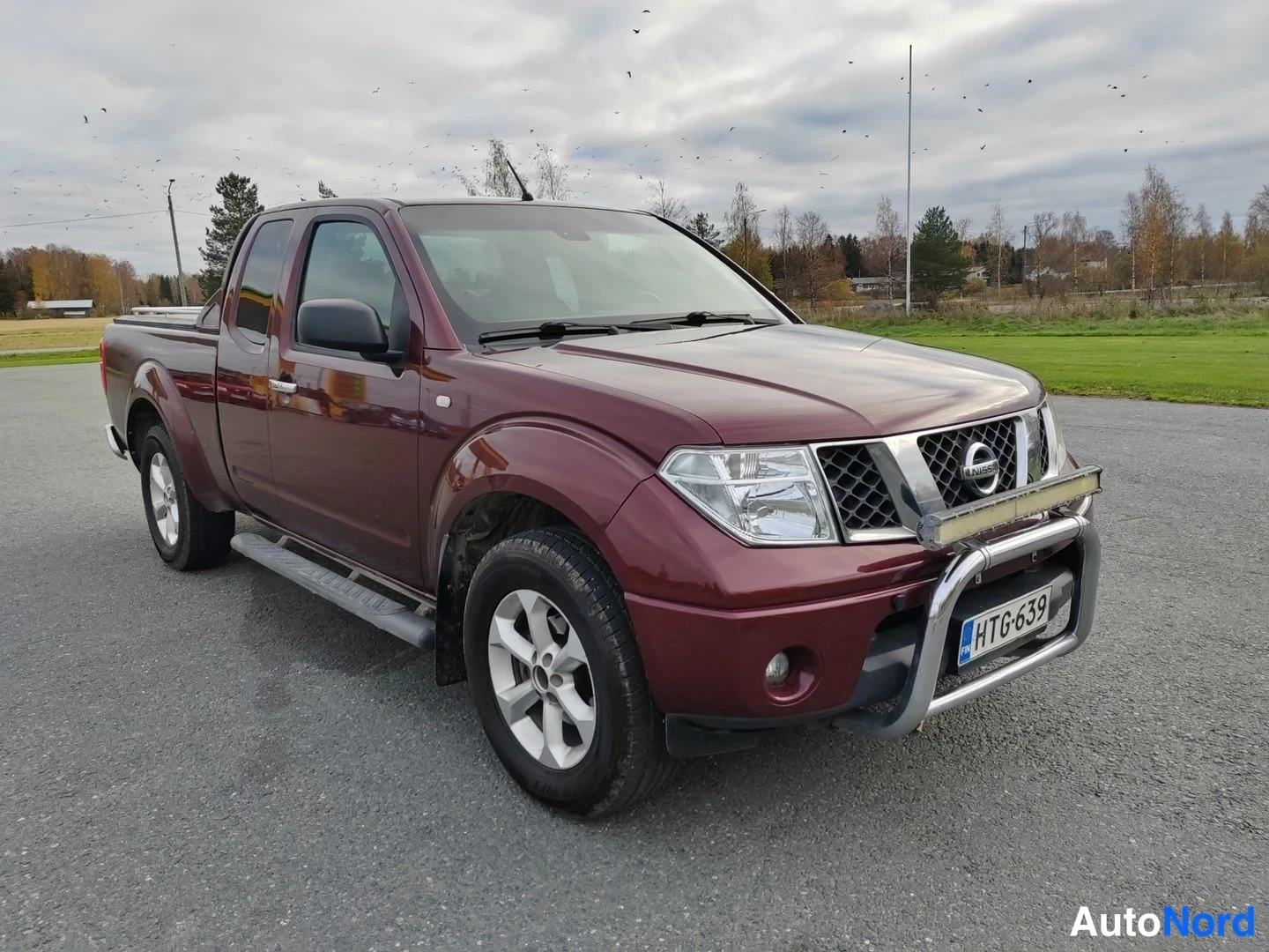 Punainen Nissan Navara 2007, etuviisto, keula oikealle, kuva 4