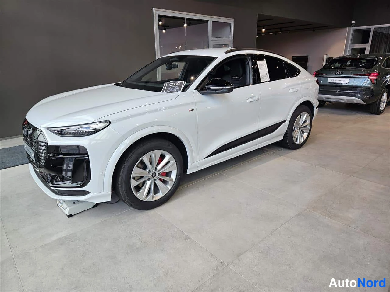 White Audi Q6 e-tron 2026, front three-quarter, nose to the left, photo 2