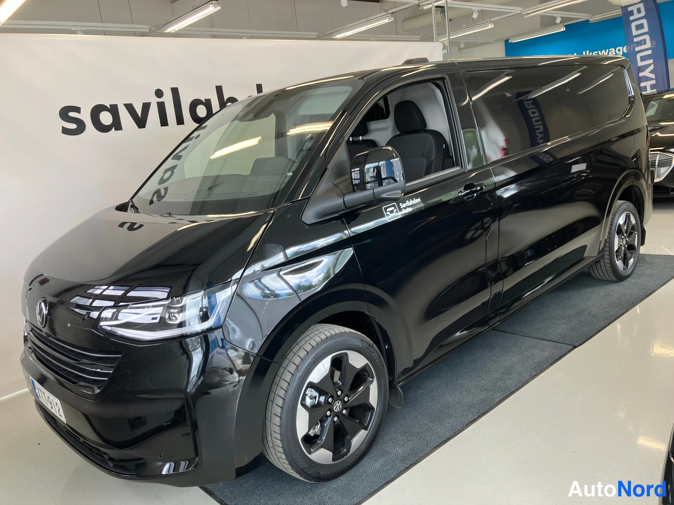 Musta Volkswagen Transporter 2026, etuviisto, keula vasemmalle, kuva 2