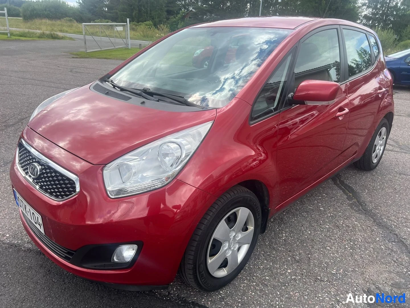 Röd Kia Venga 2013, snett framifrån, fronten åt vänster, bild 2
