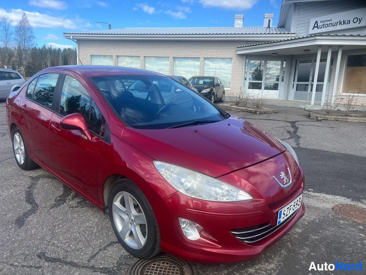 Röd Peugeot 408 2013, snett framifrån, fronten åt höger, bild 4