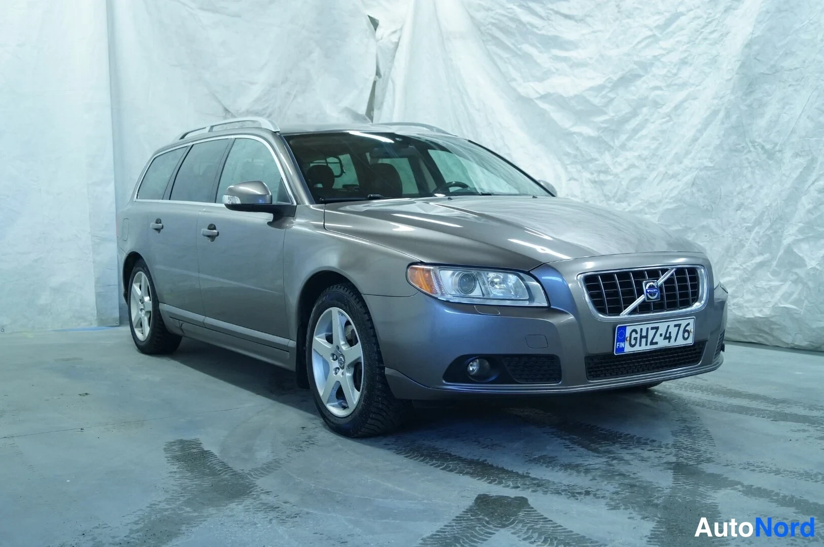 Brun Volvo V70 2008, snett framifrån, fronten åt höger, bild 2