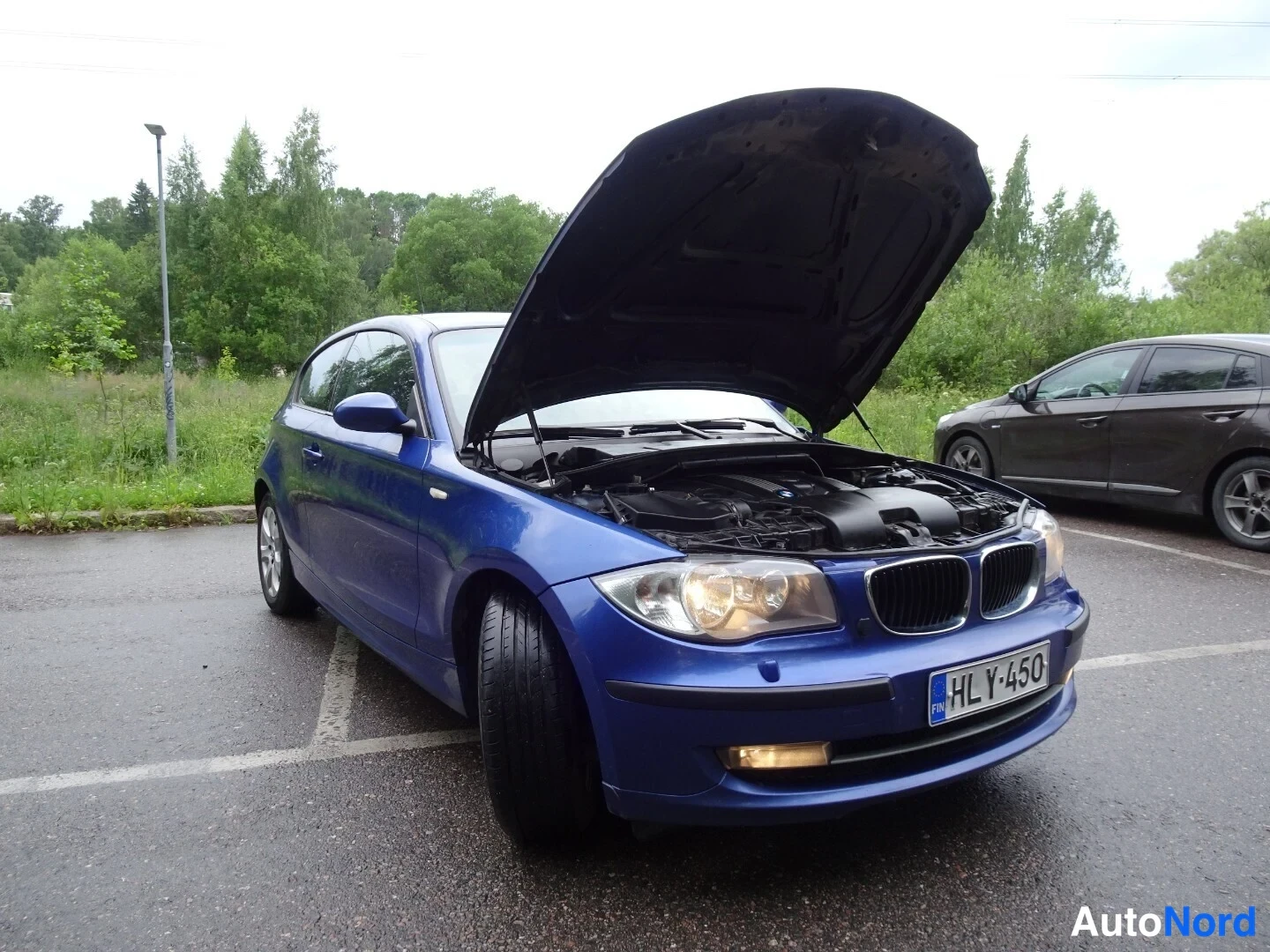 Blue BMW 116d 2010, front three-quarter, nose to the right, photo 7