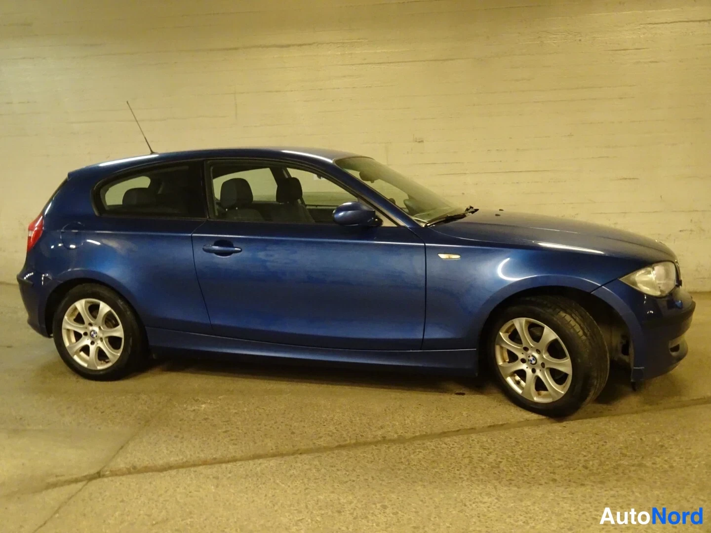 Blue BMW 116d 2010, front three-quarter, nose to the right, photo 8