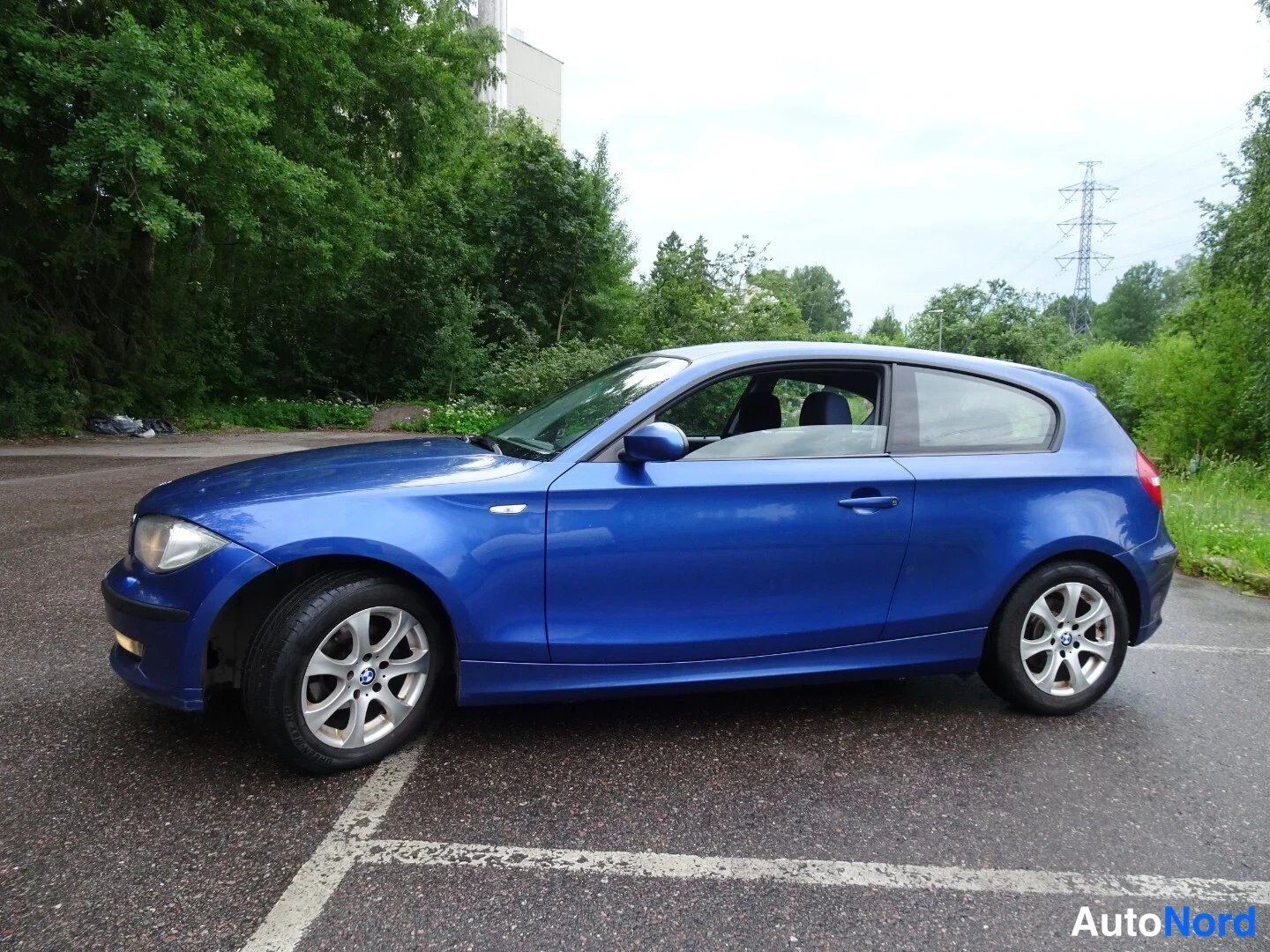 Blue BMW 116d 2010, front three-quarter, nose to the left, photo 2